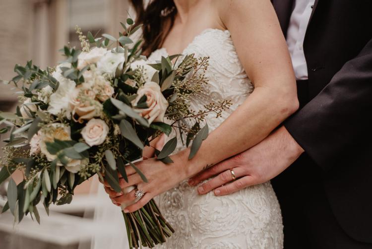 A wedding couple holding a beautiful bouquet of flowers at The Harbour Hotel wedding venue in Galway.